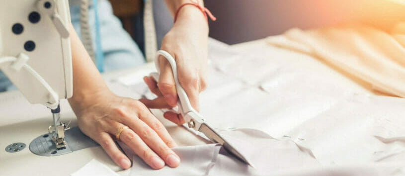 Fashion Sewing and Garment Construction Certificate. Person cutting a piece of fabric before using it for sewing.