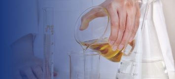 Cosmetic scientist pouring liquid into a glass container.